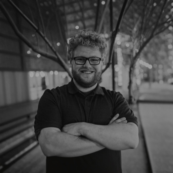 Troy, smiling with his arms crossed